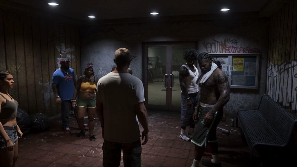 A group of people standing around a graffitied, litter-strewn lobby interior in Grand Theft Auto VI