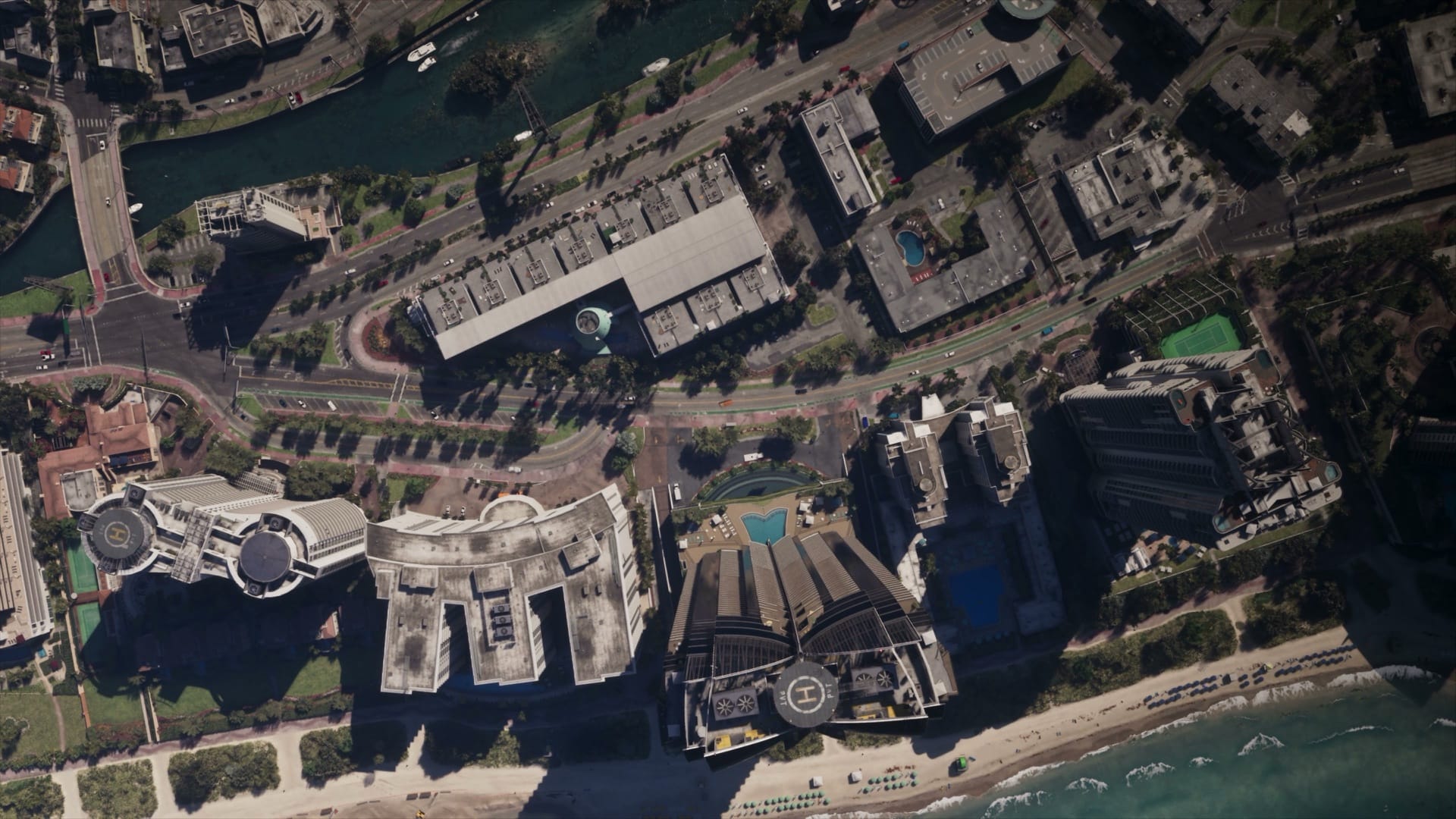 A straight-down aerial view of Vice City in Grand Theft Auto VI showing hotels, helipads, a canal and the beach