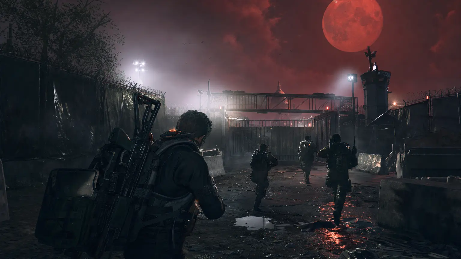 Division 2 agents in tactical gear advance through the walled-off contaminated Dark Zone of Washington D.C. at night under a huge blood-red