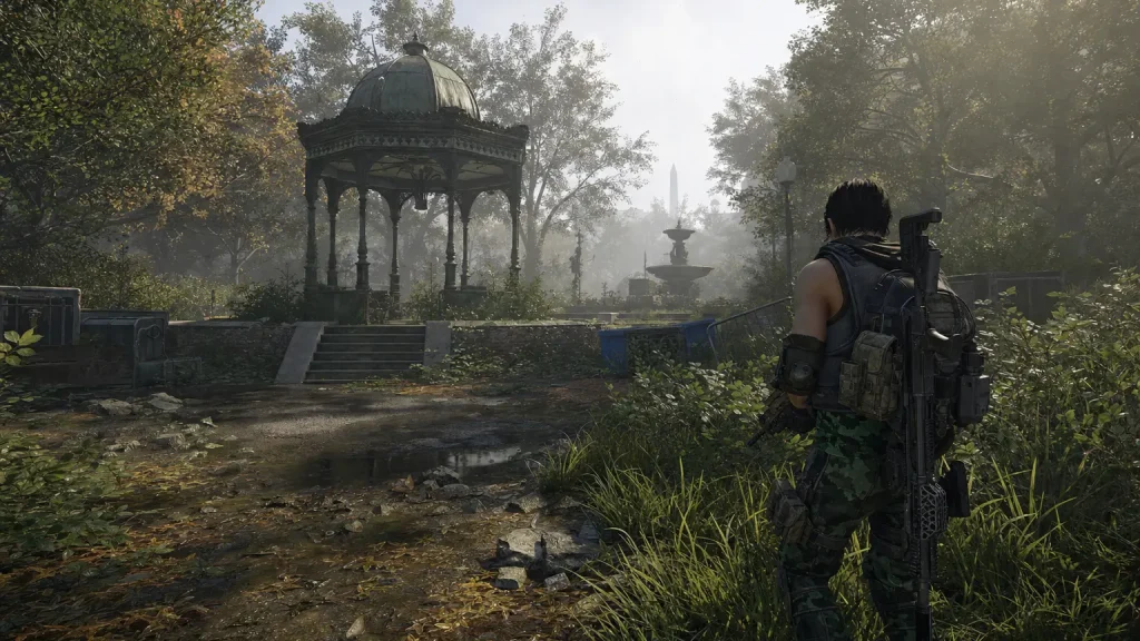 A Division 2 agent moves through an overgrown, misty Central Park in New York: a ruined ornate gazebo, a stone fountain, autumn trees and ab